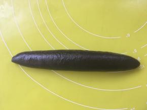 之后将面片从上往下卷起来，卷好后再用手在揉面垫上搓几下，搓成锥子的形状，两头尖一点，中间宽一点