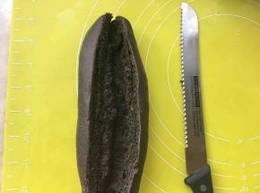用锯齿刀将面包从中间对切开，不要切到底