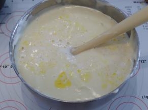 隔刮刀倒入黄油牛奶混合物，同样翻拌的手法混合蛋糕糊，面糊呈现细腻光滑的丝绸状