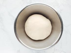 将揉好的面团放入盆中，盖上保鲜膜室温发酵。