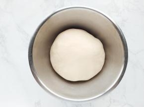 将揉好的面团放入盆中，盖上保鲜膜室温发酵。