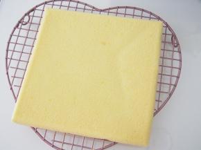 烤好的蛋糕倒扣晾至温热，此时撕下高温油布，盖上一层油纸防止表面变干燥