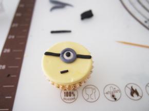 用黑色色素调出眼睛，灰色做镜框，组合成小黄人的样子就好啦