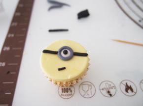 用黑色色素调出眼睛，灰色做镜框，组合成小黄人的样子就好啦