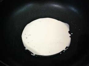 舀一汤勺的面糊倒入抹油的锅中，把锅子转动，将其均匀的铺上一层