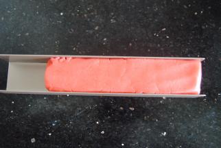 再将红色面团揉长擀开放入模具内压实，长度要和绿色的一致