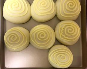 把二次发酵好的面包拿出来，同时上下火180℃预热10分钟。接着在二次发酵好的面包上涂四五圈墨西哥酱即可。