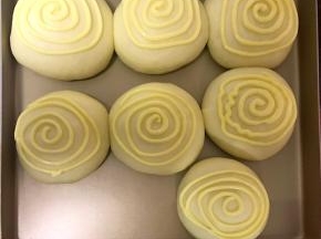 把二次发酵好的面包拿出来，同时上下火180℃预热10分钟。接着在二次发酵好的面包上涂四五圈墨西哥酱即可。