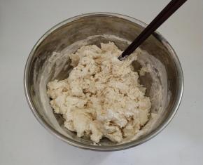 把面团用料倒入碗中混合以后，然后再加入温水，用筷子挑成絮状。