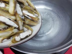 汤锅里加入适量的水大火烧开，然后把圣子放入锅中焯水，炒到圣子壳全部自动开，而且会掉下来