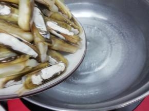 汤锅里加入适量的水大火烧开，然后把圣子放入锅中焯水，炒到圣子壳全部自动开，而且会掉下来