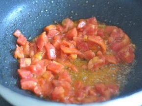 番茄切丁，锅里倒入油，放入番茄炒香。