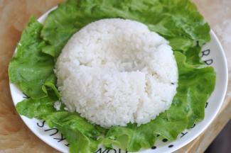 盘子里铺上生菜，将米饭倒扣在盘中，中间压出一个坑。