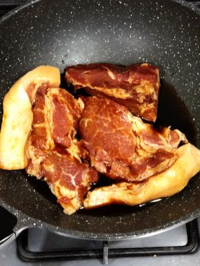 第二天就可以开始制作了，肉连同腌制的叉烧汁全部倒入锅中，中火