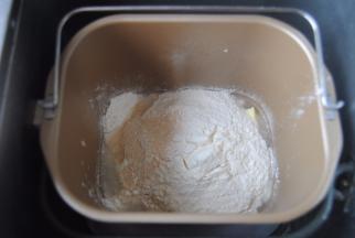 将披萨面胚材料放入面包机内