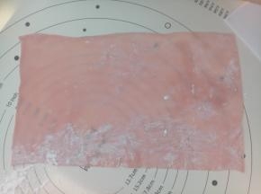 硅胶垫上撒点玉米淀粉，把外皮擀成与模具等宽的长方形（长度正好能包裹一周为宜）。