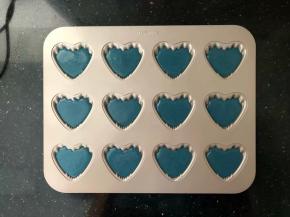 11、冷藏时间到了取出裱花袋，剪一个小口，均匀地挤入学厨心形玛德琳模具中，8分满，震出气泡。