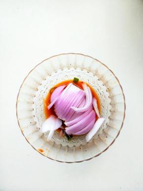 腌制鸡翅的汤汁放入半个切条的洋葱搅拌均匀