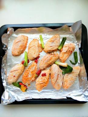 烤盘放锡纸，将腌制好的鸡翅摆放在烤盘中