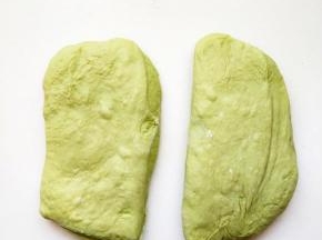 将面团拿到工作台，用刮刀切成两等份，面团表面推展开来，搓成圆形，以湿布覆盖在上面让面团静止十分钟