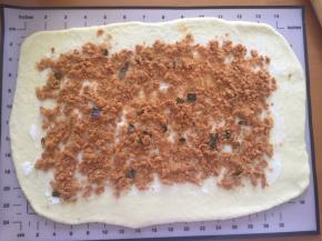 将面团拿出分成两份，擀成长方形薄片，刷上沙拉酱，撒上海苔肉松