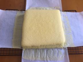 然后将油纸连蛋糕一起拿出放烤网上，撕掉四面油纸，晾凉