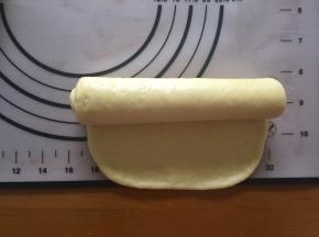 将面团擀成长方形，从上向下卷起