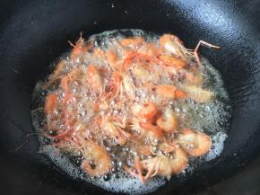 放入小河虾复炸一遍。 复炸时间不能长，小河虾的壳变脆就可以。 捞出后用笊篱沥一下油份即可。