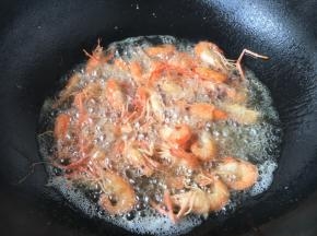 放入小河虾复炸一遍。 复炸时间不能长，小河虾的壳变脆就可以。 捞出后用笊篱沥一下油份即可。