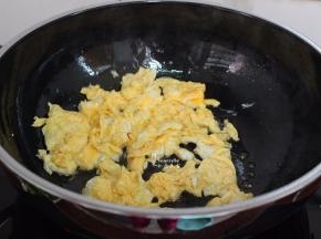 锅中放少许油，爆炒鸡蛋，不断用锅铲炒，别让鸡蛋结大块，炒八成熟