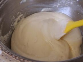 将牛奶和黄油的混合液体倒入蛋糊中，搅拌均匀