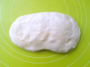 之后将面团取出，揉面垫上按压排气