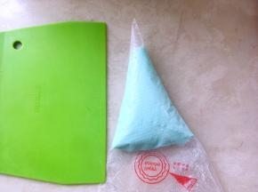 之后将调好颜色的奶酪糊装入裱花袋，冰箱冷藏留着一会淋在表面用