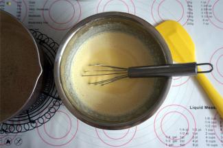 将煮过的糖牛奶慢慢加入到蛋黄糊中，边倒边搅拌。