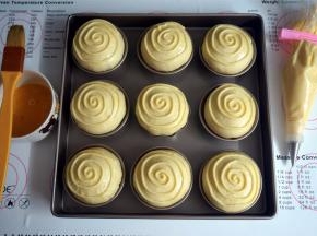 发酵结束后，在面团表面刷上一层全蛋液，转圈挤上卡仕达奶油。