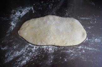 在案板上撒上干粉，然后按压面团排气。如果厨师机配有压面配件，可以用压面机排气，更方便更完全。