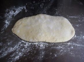 在案板上撒上干粉，然后按压面团排气。如果厨师机配有压面配件，可以用压面机排气，更方便更完全。