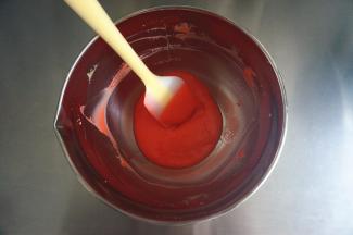 加入几滴红色素，拌均匀，将红色的蛋黄糊放置一旁备用。此时，150度上下火开始预热烤箱。