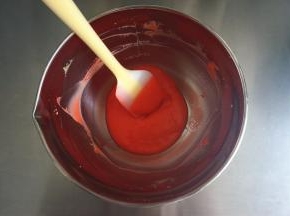 加入几滴红色素，拌均匀，将红色的蛋黄糊放置一旁备用。此时，150度上下火开始预热烤箱。