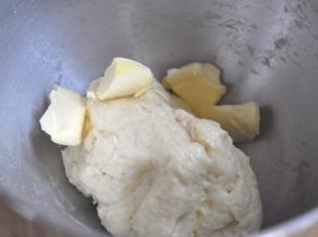 启动厨师机1档，和成面团，加入黄油，继续揉5分钟。