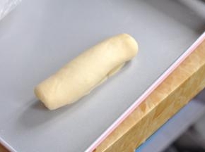 将面皮翻个面，由上至下卷起，边卷边把两边往内收，卷好后将收口捏紧。