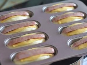 把香肠摆在芝士片上，表面刷一层蛋液。