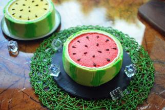 绿色的西瓜皮蛋糕切成合适的高度，围在蛋糕体外侧，稍微往内压一下，粘紧。西瓜皮和红蛋糕分界线之间，挤一圈奶油。最后用黑巧克力在表面挤成西瓜子，完成后放入冰箱冷藏保存。