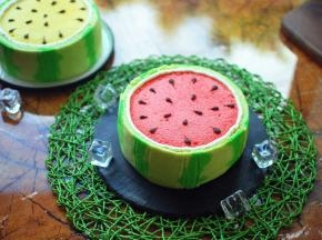 绿色的西瓜皮蛋糕切成合适的高度，围在蛋糕体外侧，稍微往内压一下，粘紧。西瓜皮和红蛋糕分界线之间，挤一圈奶油。最后用黑巧克力在表面挤成西瓜子，完成后放入冰箱冷藏保存。