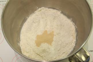 将面包的所有材料（除盐和黄油以外），先液体后粉类的顺序放入厨师机桶内，酵母放中间