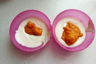 再把芒果泥分别加入到两份一样多的酸奶糊中，芒果泥一份加入少一点，一份加入多一点。