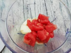 在把西红柿也放入杯中