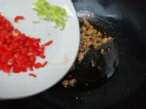在把葱和红椒放入锅中翻炒均匀