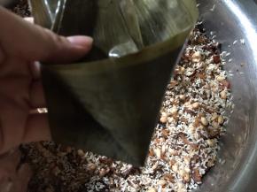 取两片粽叶两叠，分上下两端，尖细的一端卷成漏斗状的圆锥形（如图）
