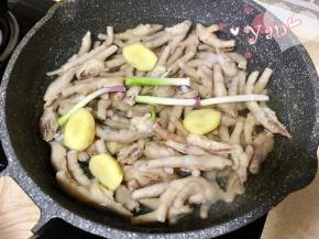 5、鸡爪放入锅里，重新加水没过鸡爪，加入30g料酒，3段葱段，4片姜片。